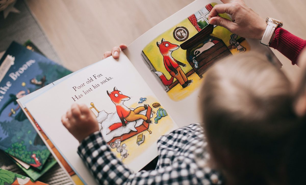 Kinder blättern gemeinsam in einem Bilderbuch